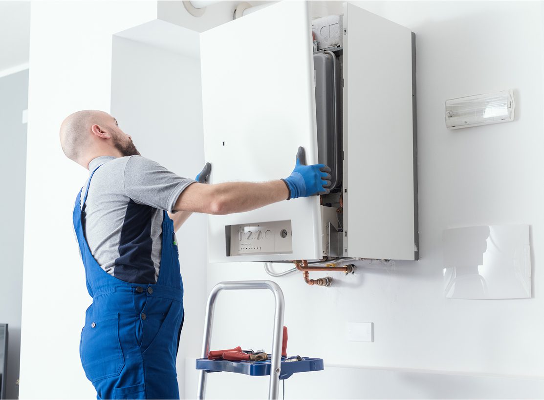 Technician installing wall-mounted water heater.