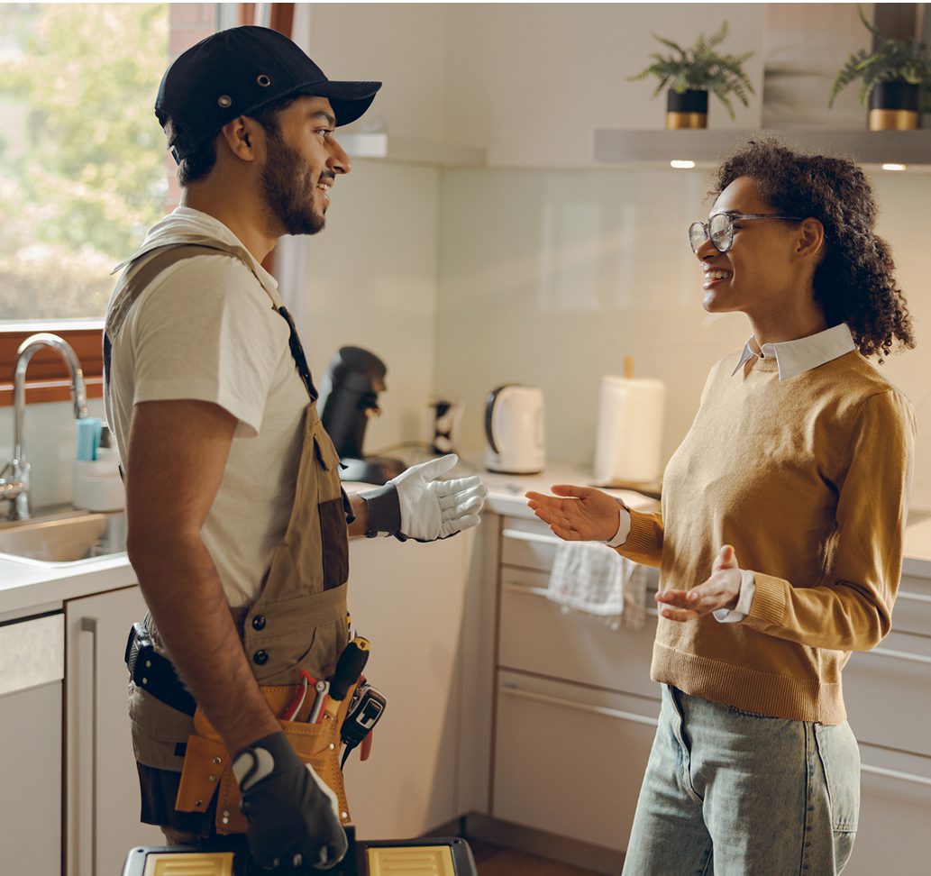 Person talking with a handyman in kitchen.