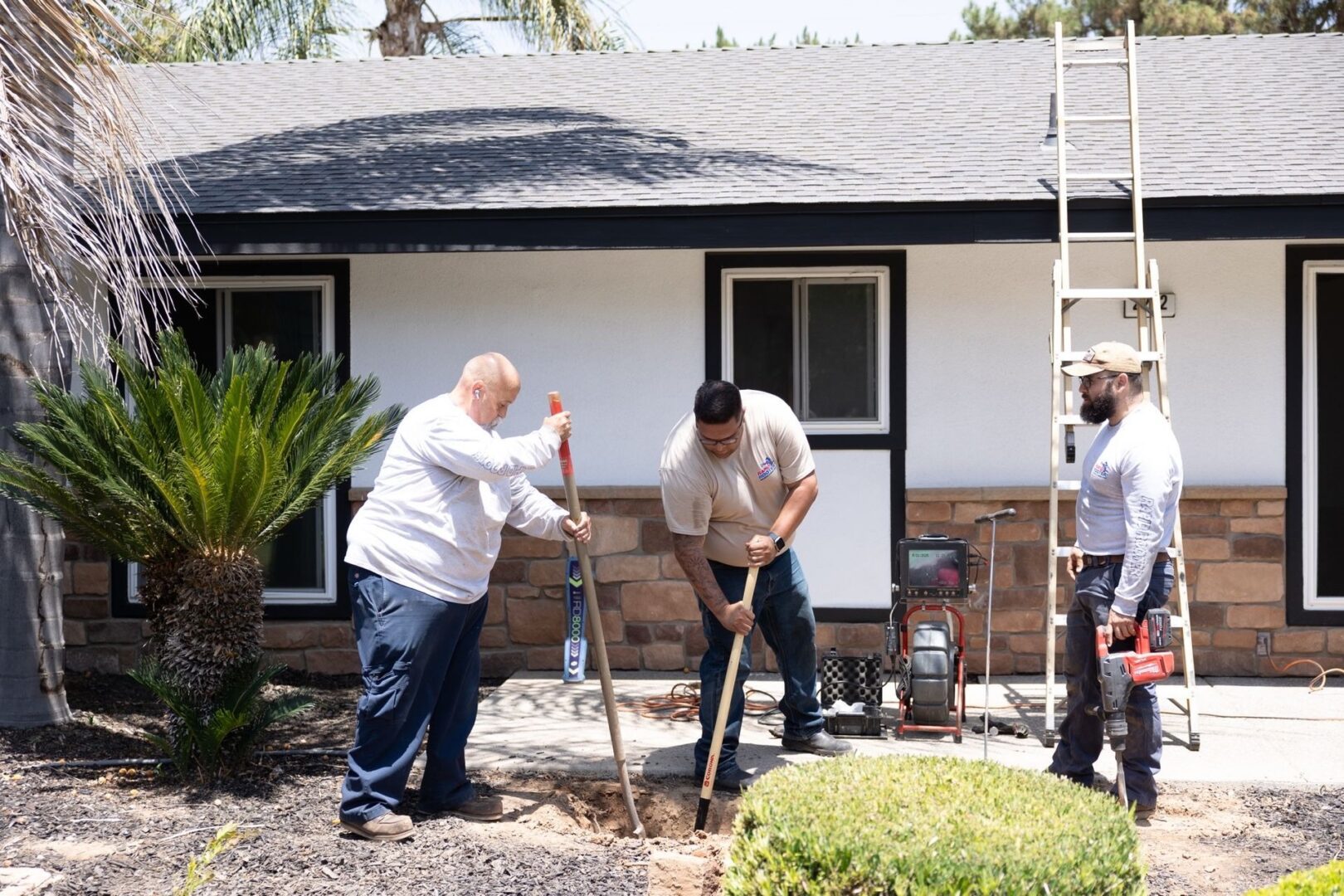 Workers digging in front of a house.